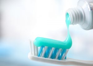 Toothpaste being squeezed onto a toothbrush