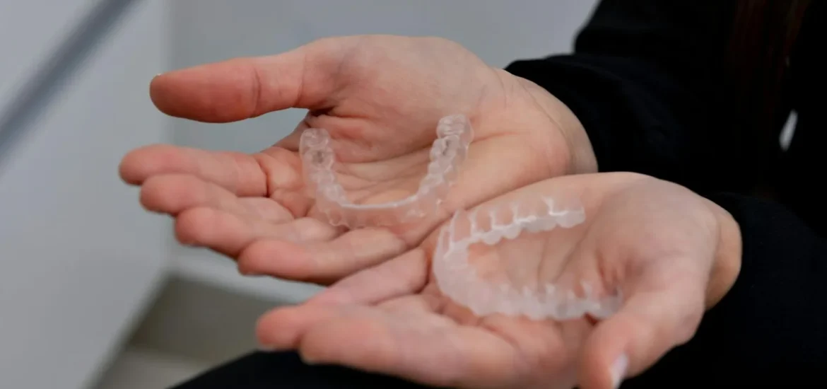 Fort collins cosmetic dentist holding clear aligners.