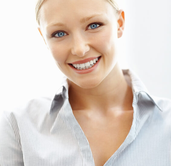 A young woman smiling after porcelain veneer treatment in Fort Collins.