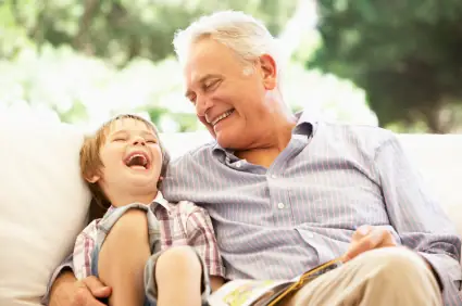 A grandfather and his grandson reading together after restorative dentistry in Fort Collins.